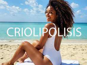 tratamiento corporal reducto frio en Logroño: mujer joven con piel firme y figura estilizada sentada en la playa con bañador blanco, sonriendo y disfrutando del sol. Imagen que refleja los beneficios del tratamiento estético para eliminar grasa localizada